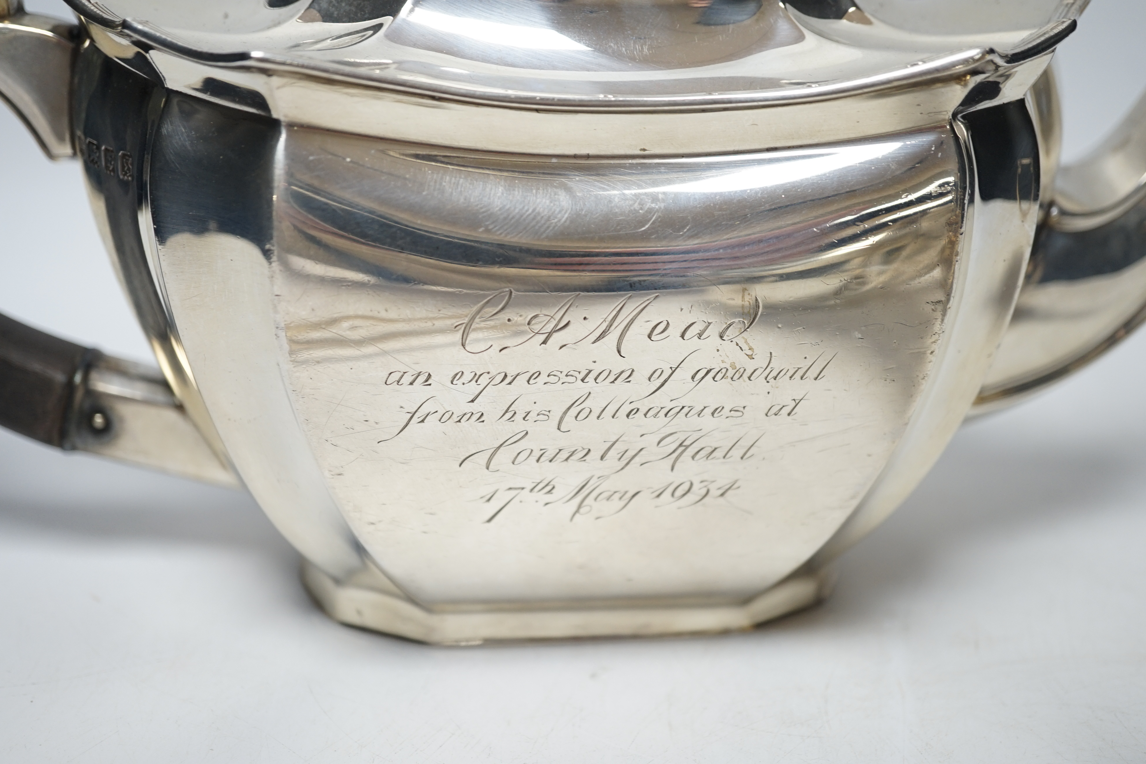 A George V three piece silver tea set by Robert Pringle & Sons, London, 1933, with engraved inscription, together with a pair of associated silver sugar tongs, gross weight 40.7oz.